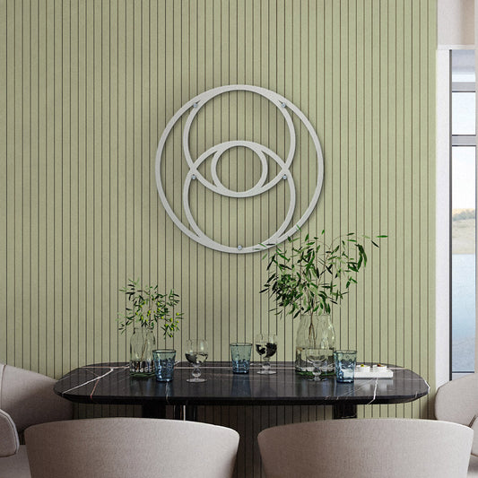 Sacred Geometry Home Decor The Vesica Pisces Metal Wall Art in copper is displayed in the center of the dining room, which includes a wooden table and six wooden chairs with green cushions, a carpet, and two wooden cabinets with decorations.